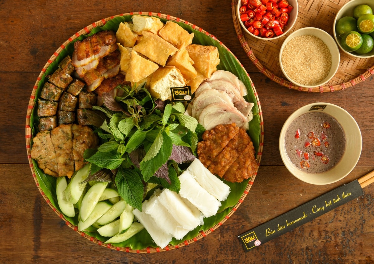 he dish, usually served on a round bamboo tray lined with banana leaves, features fresh noodles, fried tofu, boiled pork, herbs, and shrimp paste